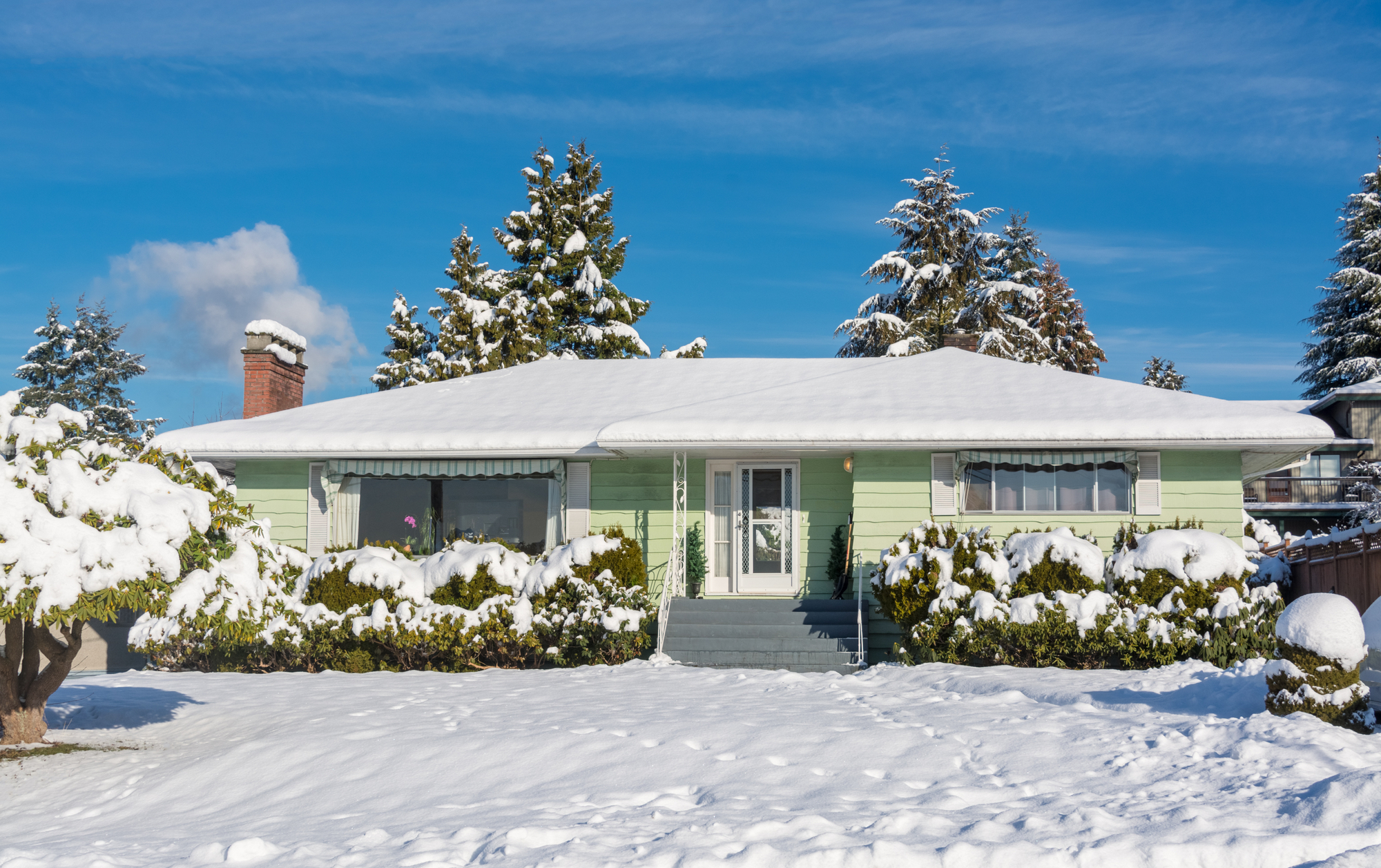 Green house with full of snow at the front